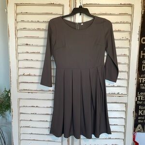 Women’s dress with 3/4 length sleeves and pleated skirt.